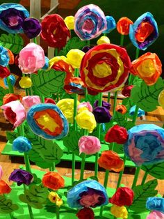 colorful paper flowers are on display in a vase