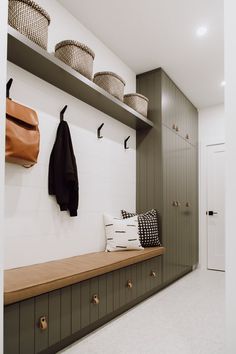 a coat rack with two coats hanging on it next to a bench in a hallway