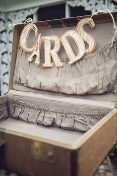 an open suitcase with the word cards hanging from it's lid, sitting on top of a table