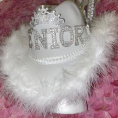 Super fun and gorgeous nice quality white felt cowboy hat for homecoming or special day.  We can customize the name or word in the middle of the hat.   It includes a mini mum on the back & boa on edge.  We also have a rhinestone trim option instead of boa trim.  We have most ribbon colors available, just let us know what colors you would like.  Trinkets and other customizations can be added- prices vary.  USPS Priority shipping in a box is included.  Please let us know if you have any custom requests. Senior Cowboy Hats Decorated, Senior Cowgirl Hats, Hoco Cowboy Hats, Senior Cowboy Hats, Dance Mums Homecoming, Homecoming Cowboy Hats, Senior Hats, Spirit Cowboy Hat, School Spirit Cowboy Hats