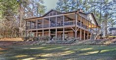 a large house sitting in the middle of a forest with lots of trees around it