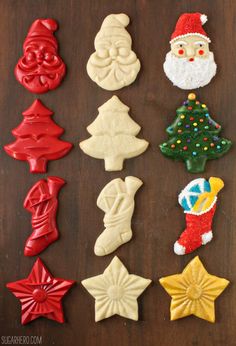 christmas cookies decorated like santa claus, snowman, and other holiday decorations on a wooden table