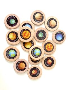 small wooden magnets with solar system images printed on them, all in different colors and sizes