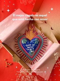 an open box with a heart shaped cookie in it on a red background and the caption reads, el mejor regadlo es agueles que que que que que que que que que est hecho con amar