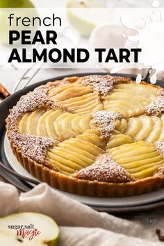 there is a pie on the plate with almonds and powdered sugar