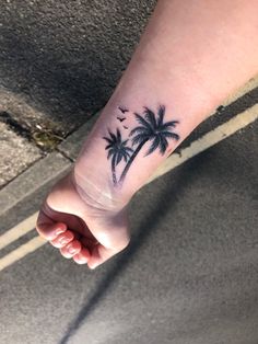 a small palm tree tattoo on the wrist