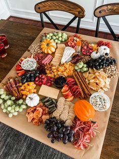 a table topped with lots of different types of cheese and crackers next to two chairs