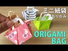 an origami bag is being held up by someone's hand with other small bags in the background