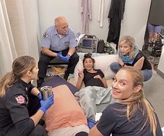 a group of people sitting around each other in a room with medical equipment on the floor