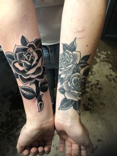 two people holding hands with tattoos on their arms and one has a rose tattooed on the arm