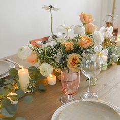 the table is set with flowers and candles