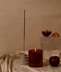 a candle and some fruit on a table