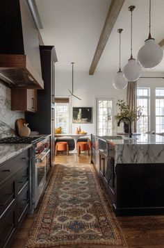 a kitchen with marble counter tops and an area rug in front of the stove top