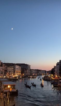 boats are traveling down the river at dusk