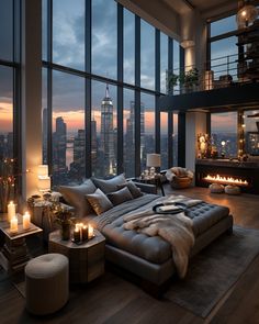 a living room filled with lots of furniture and tall windows overlooking the city at night