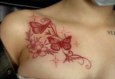 a close up of a woman's chest with flowers and butterflies tattoo on it