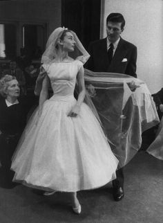 a woman in a wedding dress is standing next to a man