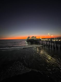 a pier at night with the sun setting