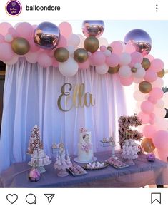 a table topped with lots of pink and gold balloons