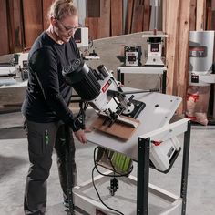 a woman standing in front of a table with a machine on it's side