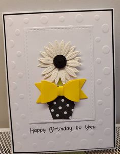 a birthday card with a sunflower and polka dot bow tie on it, sitting on top of a table