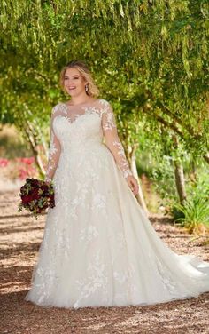 a woman in a wedding dress standing under trees