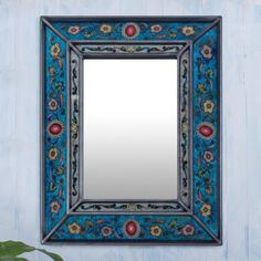 a blue mirror hanging on the side of a wall