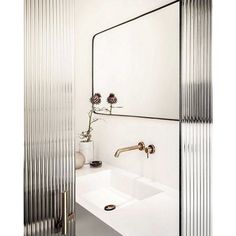 a white sink sitting under a mirror next to a faucet in a bathroom