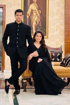 a man and woman in formal wear posing for the camera