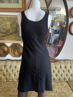 a mannequin wearing a black dress in front of a mirror