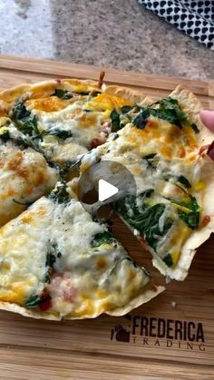 someone is cutting into a pizza with cheese and spinach