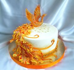 a white cake with orange and gold decorations