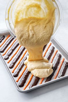 an ice cream scooping from a tray with chocolate covered donuts