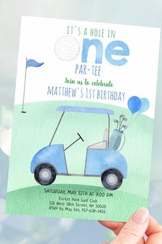 a person holding up a birthday card with a golf cart on the front and blue balloons in the back