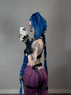 a woman with blue hair and tattoos taking a selfie while wearing purple tights