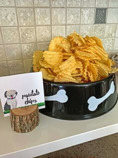 a bowl full of chips next to a sign with a dog's bone on it