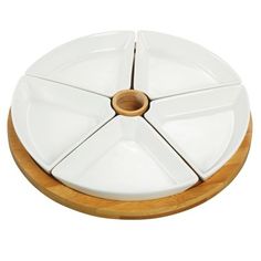 a white cake plate with four sections on a wooden base and one piece missing from the top