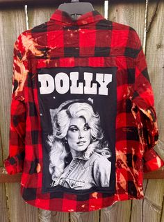 This is a one of a kind Dolly Parton plaid flannel shirt.  This size LARGE plaid shirt has two pockets on the front, buttons up and is long sleeve. On the back of the shirt is a Dolly Parton tee that has been sewn on to the back of the shirt. The flannel has been bleach giving it an overall distressed vintage style look.  All my shirts are ONE OF A KIND. They are all upcycled by being previously owned so there will be signs of wear and tear. This is what make each shirt unique in its own way and for sure makes them the most comfortable.  *NOTE: ALL of our shirts are MENS sizes unless otherwise stated above.  Upcycled/Bleached/Distressed Long Sleeve Size Large 100% Cotton Button Up Here are some ways to style your flannels.  1) wear cowboy boots or tennis      shoes with it. 2) wear it with Distressed Long Sleeve Shirt For Fall, Grunge Cotton Shirt For Fall, Distressed Cotton Shirt For Fall, Distressed Relaxed Fit Shirt For Fall, Distressed Button-up Shirt For Fall, Grunge Cotton Flannel Shirt For Fall, Fall Long Sleeve Flannel Shirt With Graphic Print, Fall Cotton Flannel Shirt With Graphic Print, Fall Flannel Shirt With Graphic Print