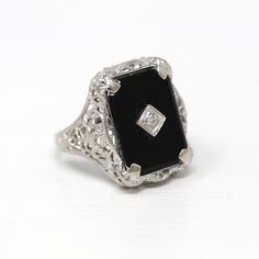 Lovely vintage circa 1930s era Art Deco 10k white gold genuine onyx ring! This pretty vintage ring features a genuine black onyx gemstone, that features a genuine diamond in the center. The setting has classic floral filigree designs, and the shank is free of design. A fantastic piece of fine Art Deco era jewelry, from the 1930s!  ERA - Circa 1930s - Art Deco METAL / MATERIAL - 10k white gold, genuine onyx, genuine diamond (approx. .01 CT)  MARKINGS / HISTORY - Inside of band is marked "A&S 10K" Vintage 14k White Gold Gemstone Jewelry, Classic Black Enamel Wedding Rings, Vintage Black Enamel Wedding Rings, Antique Black Filigree Ring For Formal Occasions, Art Deco Onyx Jewelry For Weddings, Antique Black Filigree Rings, Vintage Sterling Silver Ring With Black Enamel, Vintage 14k White Gold Jewelry, Vintage Sterling Silver Rings With Black Enamel