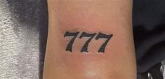 a small wrist tattoo with the number 777 on it's left side arm