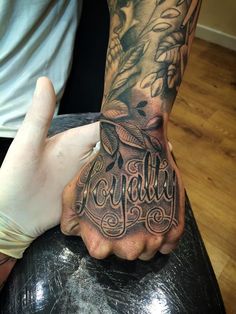 a person with a tattoo on their arm holding onto another persons hand that has the word tequila written in it