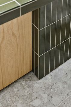 a counter top sitting next to a wooden cabinet in a room with tile on the floor