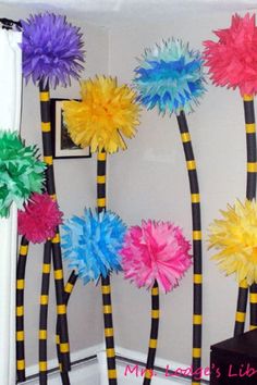 some colorful pom poms are hanging on the wall