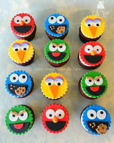 twelve cupcakes decorated like sesame street characters