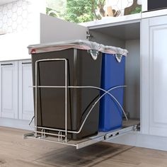 two trash cans sitting in the middle of a kitchen with white cabinets and wood floors