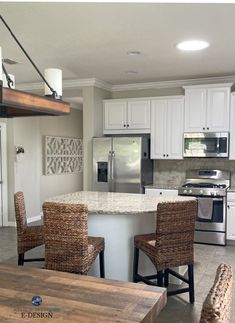 the kitchen is clean and ready to be used for cooking or eating, with wicker chairs around the island