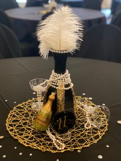 a black table topped with a bottle of champagne and a wine glass holder filled with pearls