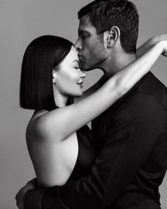 a man and woman kissing each other in black and white