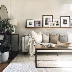 a living room filled with lots of furniture and pictures on the wall above it's coffee table