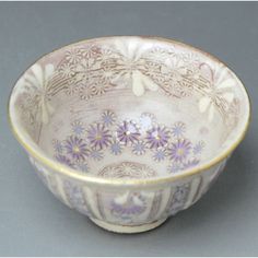 a white and purple bowl with flowers on it